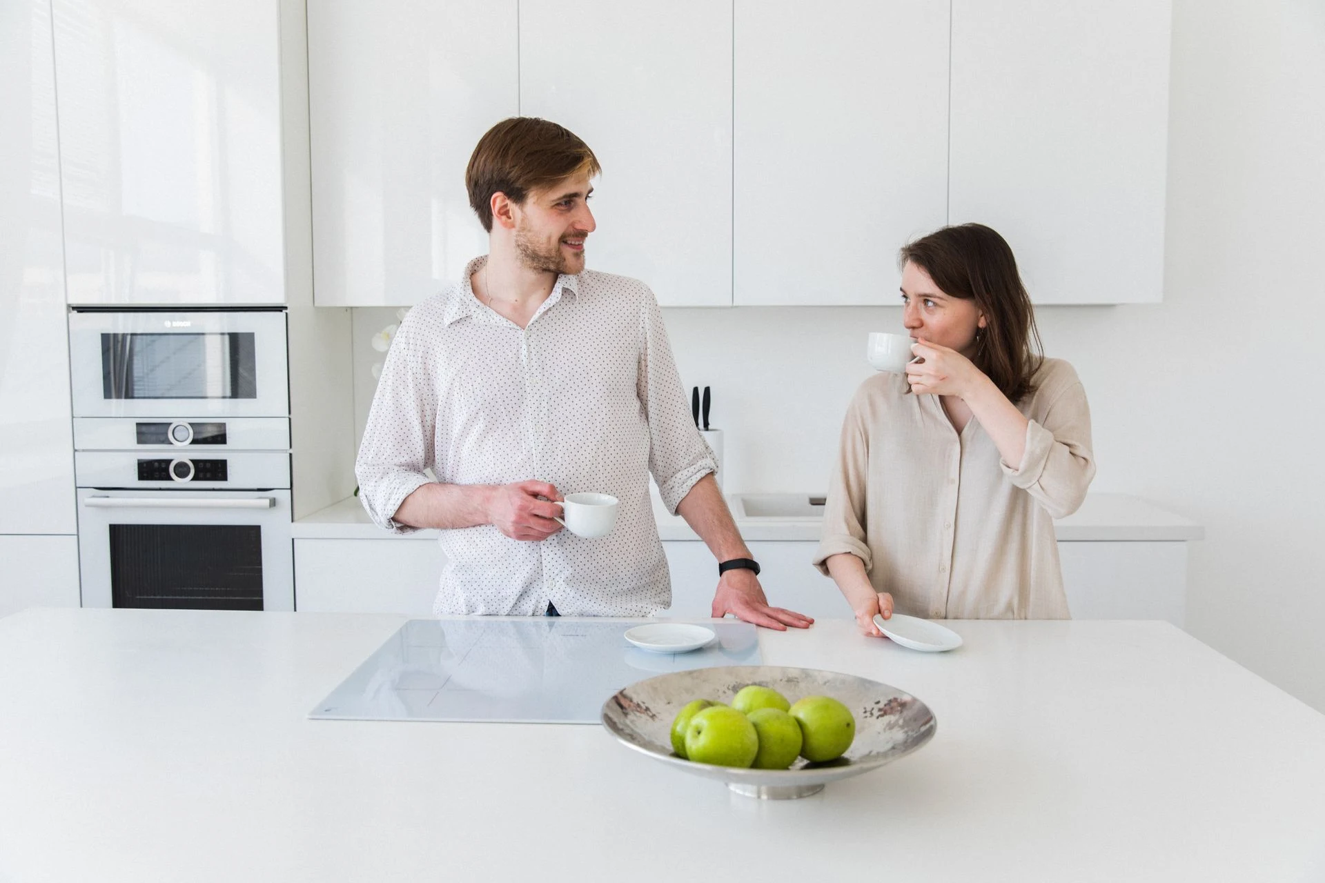 Couple talking over coffee in their kitchen at home