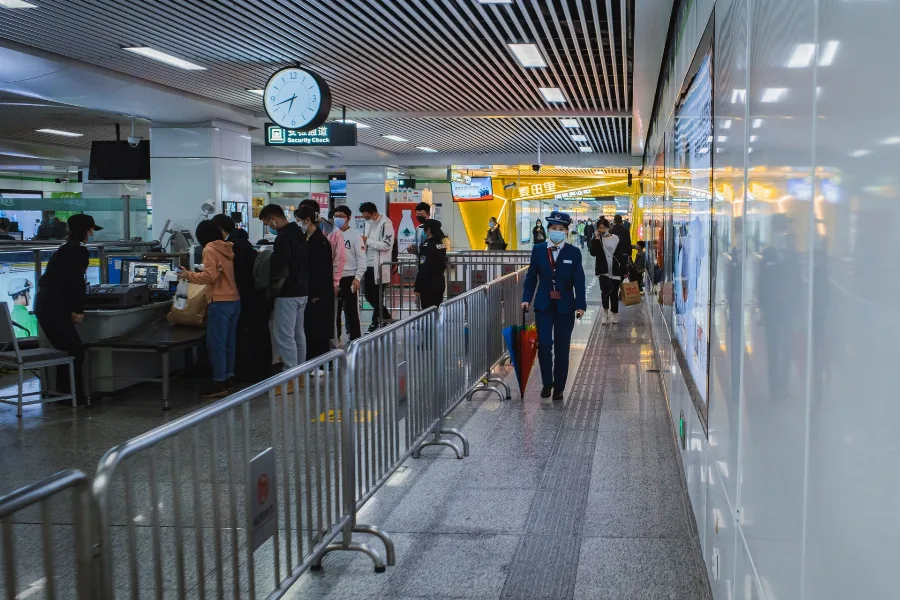 Passengers queuing between barriers in an airport terminal