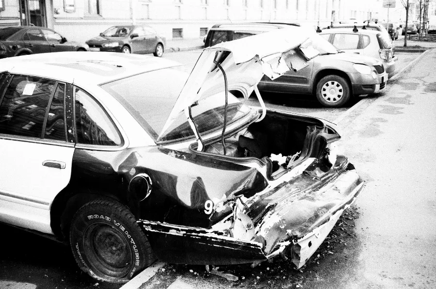 Car with a crushed front end after a collision, black and white