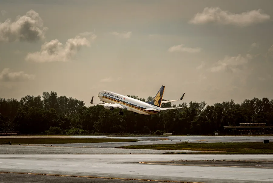 Passenger aircraft taking off from a runway under a cloudy sky