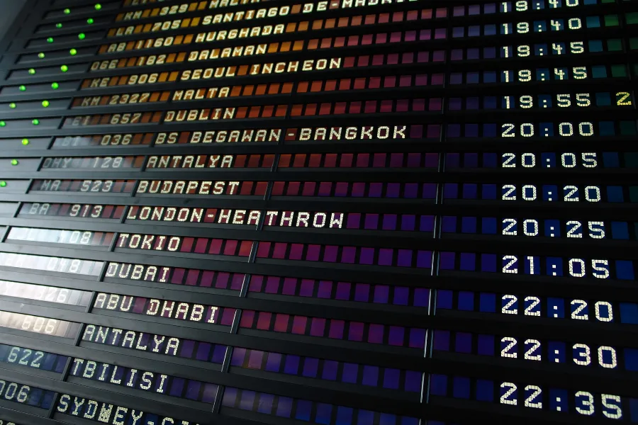 Airport departure board listing international destinations and times