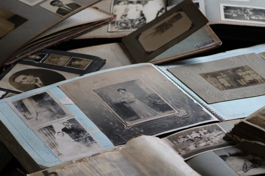 Old family photographs and albums spread on a table