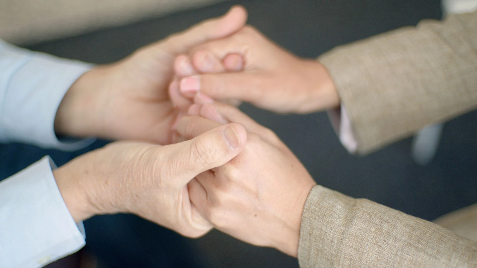 One person holding another's hands in support