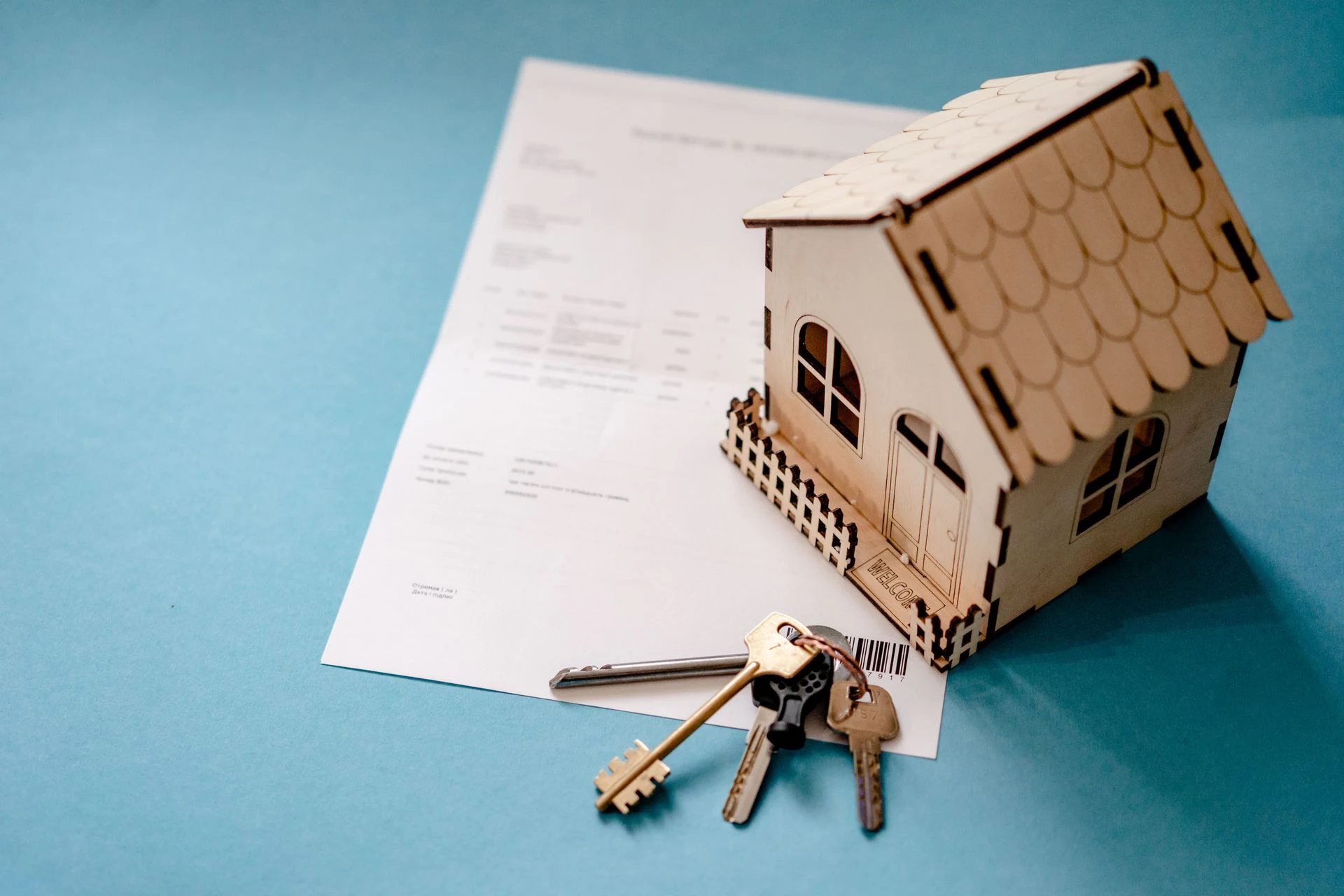 Model house and keys lying on a signed contract