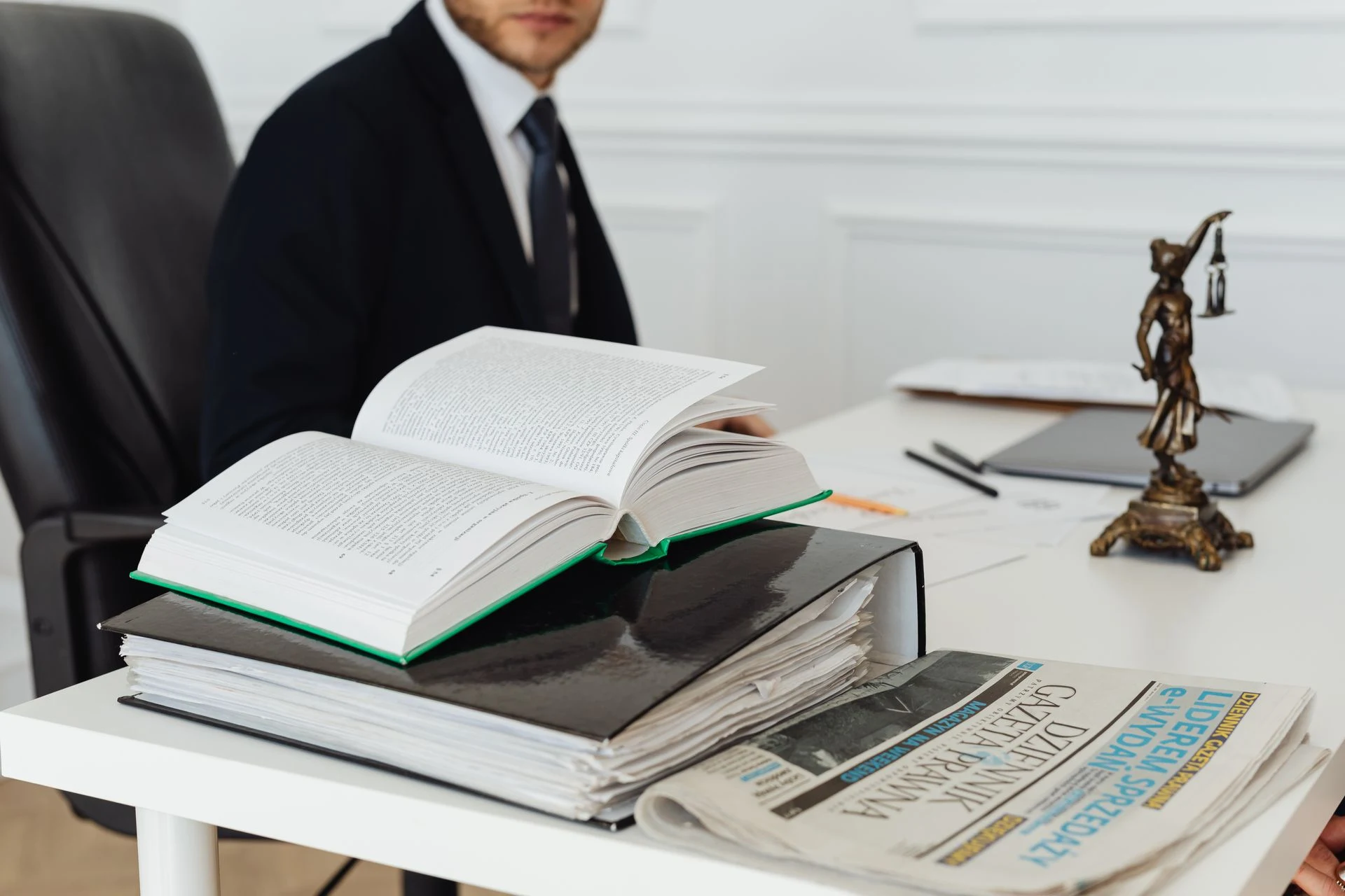 Open law book and a statue of justice on a lawyer's desk