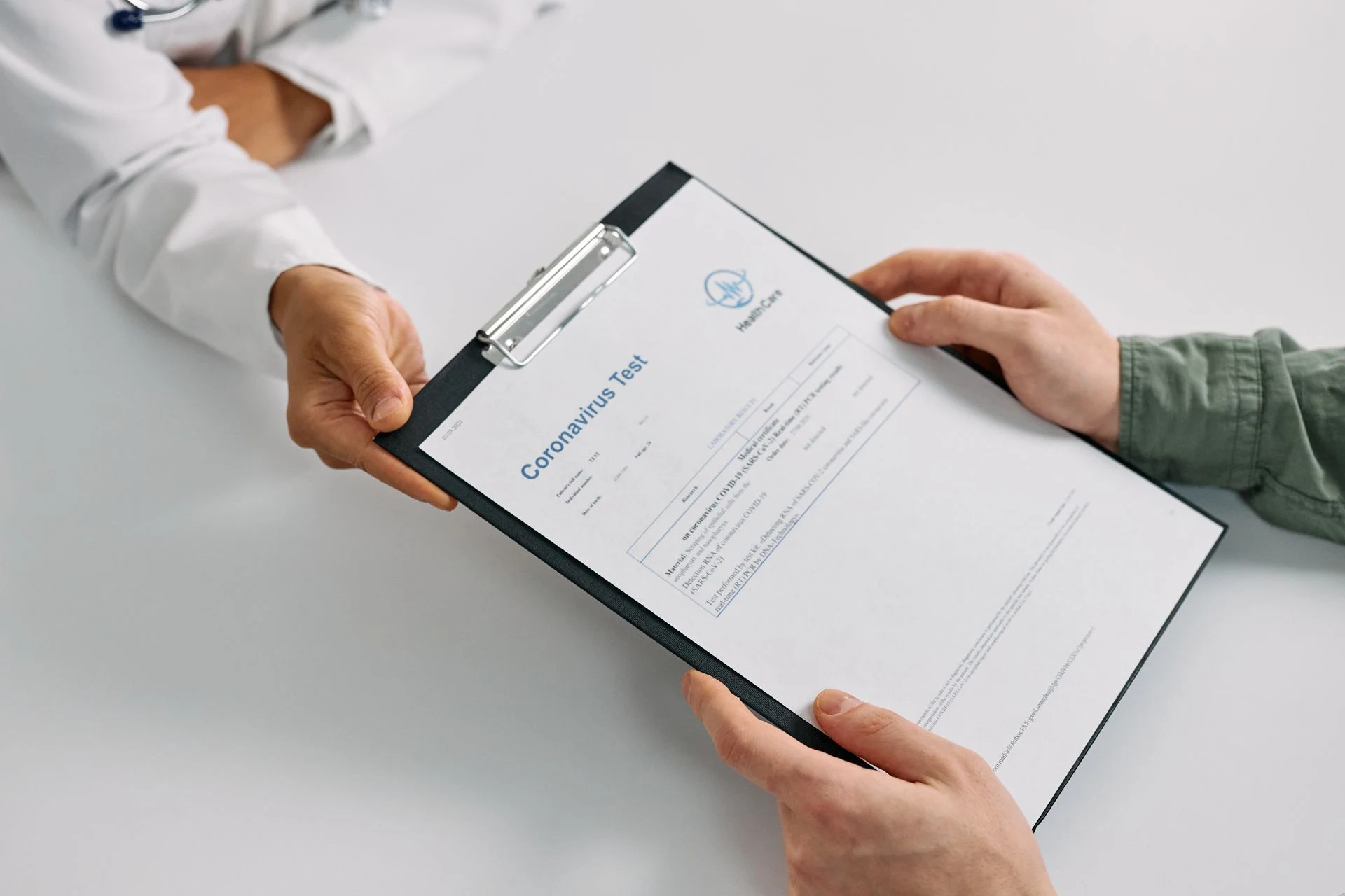 Doctor handing a clipboard with a medical report to a patient