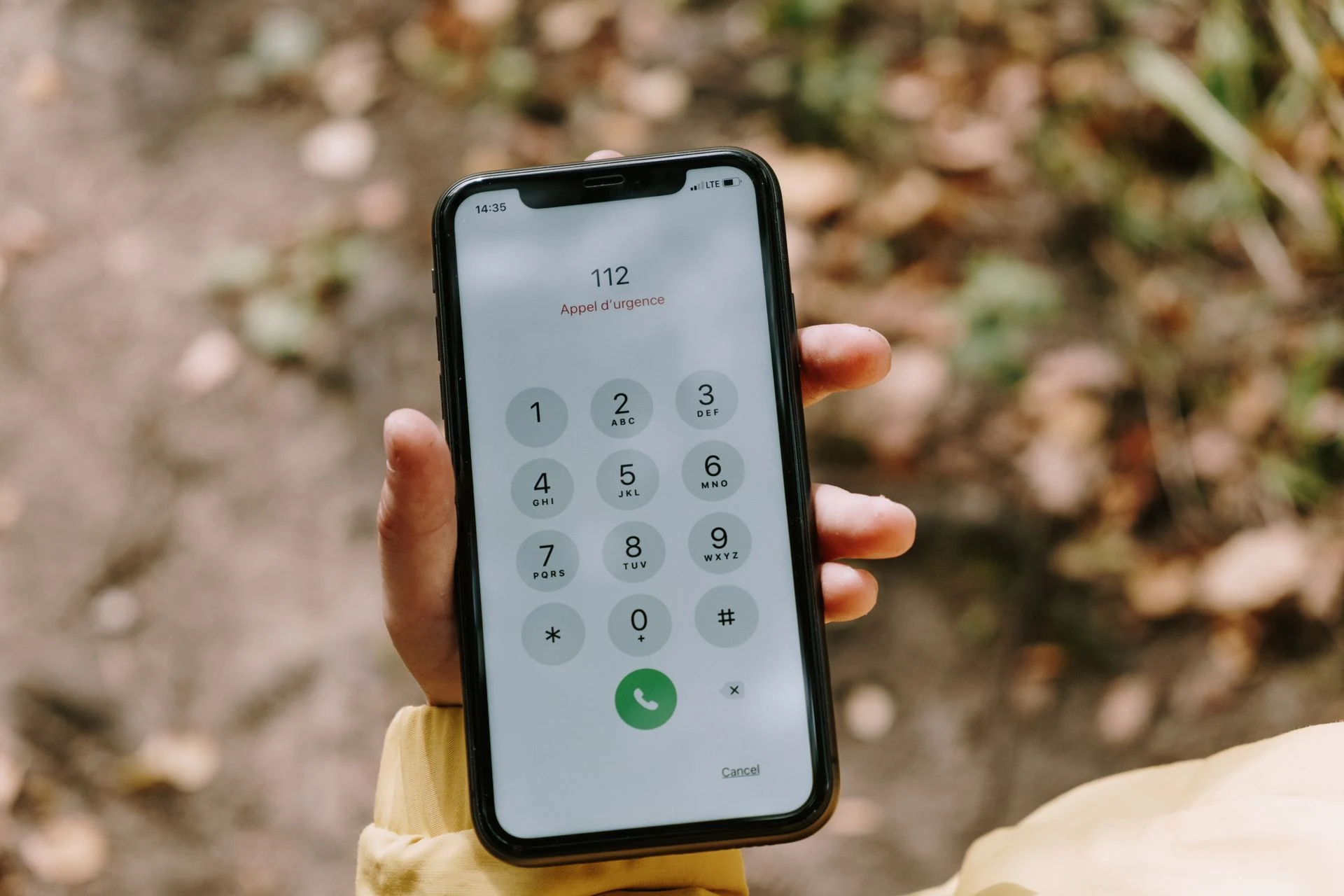 Hand holding a smartphone showing the dial pad