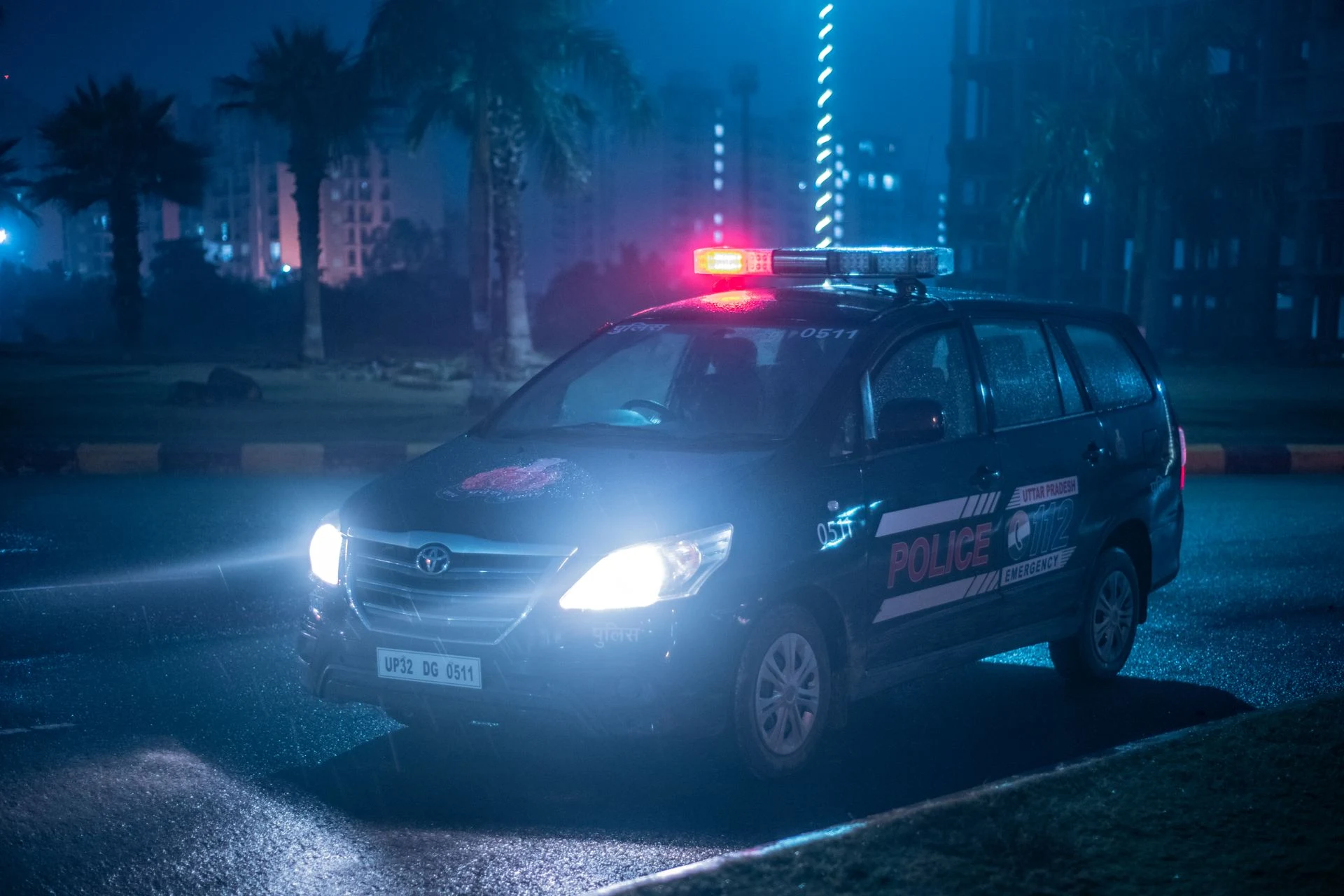 Police car with blue lights on a dark street at night
