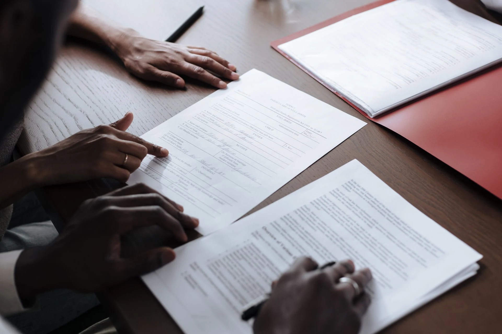 Hands reviewing printed legal documents on a desk