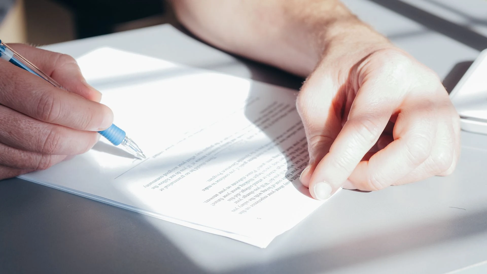 Hand signing a printed document with a pen